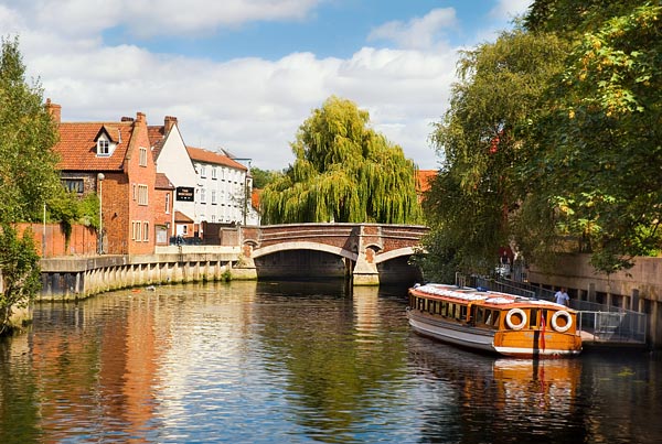 A boat travels down the River Wensum in Norwich